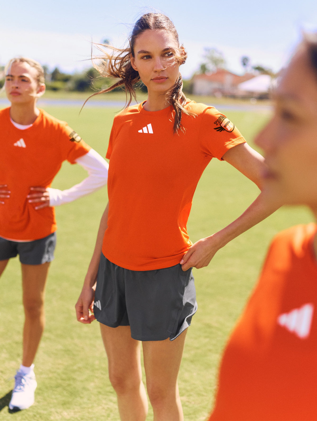 Athletes wearing orange team apparel outdoors