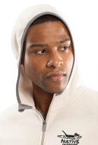 A person wearing a light-colored CHILL FLEECE 2.0 FULL ZIP HOODIE with the hood up, featuring a small NATIVE logo and bird graphic on the chest—crafted for comfort and style, looking slightly to the side.