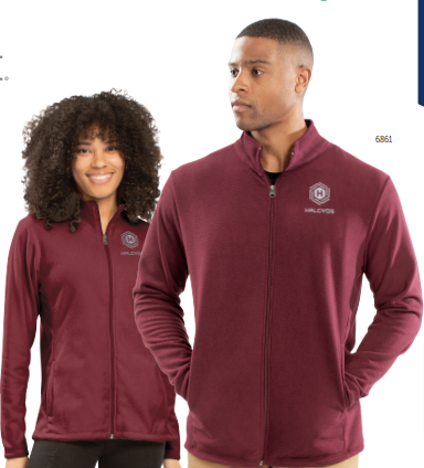 Two models wear matching maroon MICRO-LITE FLEECE FULL ZIP JACKETS with a gray HALCYON logo on the left chest. Made from recycled polyester in an eco-revive design, the ladies’ fit flatters her look while he gazes to the side.